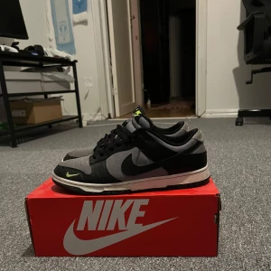 Nike Dunks - Snygga Nike Dunk sneakers i svart och grått med limegröna detaljer. Säljs eftersom jag har tröttnat på de. Kvitto och box medföljer och skorna är i bra skick.