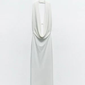 Vit långklänning från Zara - Elegant vit långklänning från Zara med draperad framsida och djup urringning. Perfekt för en stilren och sofistikerad look. Aldrig använd, lappen kvar. Storlek L men sitter som en M