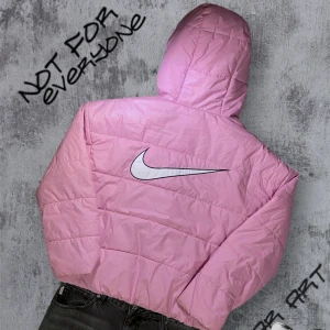 Rosa vintage pufferjacka från Nike - Säljer en snygg rosa pufferjacka från Nike med huva och dragkedja. Jackan har en stor Nike-logga på ryggen och mindre logga på bröstet. Den är vadderad och har praktiska fickor med dragkedja. Perfekt för kyliga dagar! Det finns små skavanker så vill ni se så skicka ett meddelande till mig så fixar jag mer bilder 🫶
