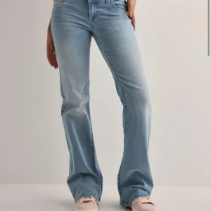 Ljusblå bootcut jeans - Snygga ljusblå bootcut jeans med låg midja och söta broderade detaljer på bakfickorna. De har en klassisk femficksdesign och stängs med dragkedja och knapp. Köptes för 700 kr från Nelly för en månad sen och har används 2 gånger, säljer för jag har för många jeans☺️ är 164 och passar perfekt💓