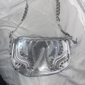 Glitter kristall väska Zara 💎✨ - En otrolig partyväska från Zara! Helt oanvänd. Små små ”strass” stenar i den här otroliga silvriga färgen. Blir så otroligt lyster när man lyser på den! 24cm längd. Stängs med dragkedja och Axel-bandet är lite justerbart som ett bälte. Ej prislapp men aldrig använd. Köptes på Zara i Tokyo! 