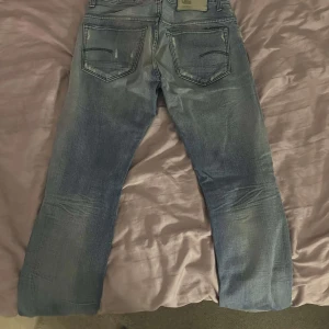 Blå jeans från G-Star RAW - Snygga blå jeans från G-Star RAW med en klassisk femficksdesign. De har en knappgylf och en rak passform. Nästan lite slim 