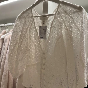 Vit broderie anglaise blus från H&M  - Superfin blus från hm! Tyget är i broderie anglaise, superfina klädda knappar fram till. Figursydd och super så fint! 