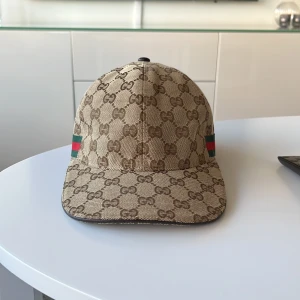 Beige Gucci keps - Säljer denna snygga gucci kepsen i size M. Kepsen är självklart äkta. Skick är 10/10. Sällsynt. Finns inget dåligt att säga om den. Hör av er för mer frågor. Släpper billigare vid snabb affär.