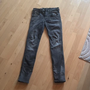 Grå Replay Anbass jeans - Snygga grå Replay Anbass jeans i slim fit. De har en klassisk femficksdesign med dragkedja och knapp framtill. Perfekta för en stilren look. Storlek 28/30 har användts 1 gång ! 