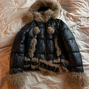 RACER WORLDWIDE JACKET - Slim fit puffer jacket with detachable faux fur parts. Made of light shiny nylon fabric. Detachable fur on hood, neck and cuffs. Silver silkscreen print on the front, back and inside. Two side-pockets on the front with snap button closure. 