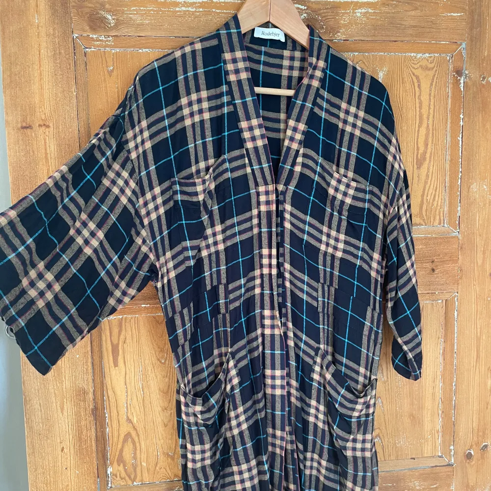 Säljer en superfin rutig kimono /klänning från Rodebjer i storlek XS. Den är tillverkad i viskos och flanell, har en avslappnad passform med trekvartsärmar. Perfekt för höst och vinter. Knappt använd. Använd endast två gånger. Styla med jeans och höga boots. Modell LULU FLANELL. Fina fickor och midjeband. Otroligt skön. Viskose med flanellkänsla. Xs men rymlig. Mer som S.. Mekot.