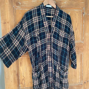 Rutig kimono från Rodebjer - Säljer en superfin rutig kimono /klänning från Rodebjer i storlek XS. Den är tillverkad i viskos och flanell, har en avslappnad passform med trekvartsärmar. Perfekt för höst och vinter. Knappt använd. Använd endast två gånger. Styla med jeans och höga boots. Modell LULU FLANELL. Fina fickor och midjeband. Otroligt skön. Viskose med flanellkänsla. Xs men rymlig. Mer som S.