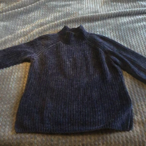 Mörkblå stickad tröja - Säljer en mysig mörkblå stickad tröja i storlek S. Perfekt för kalla dagar med sin varma och bekväma passform. Tröjan har en liten defekt på ärmen, men är annars i bra skick. Passar perfekt till höst- och vintergarderoben! 🍂❄️