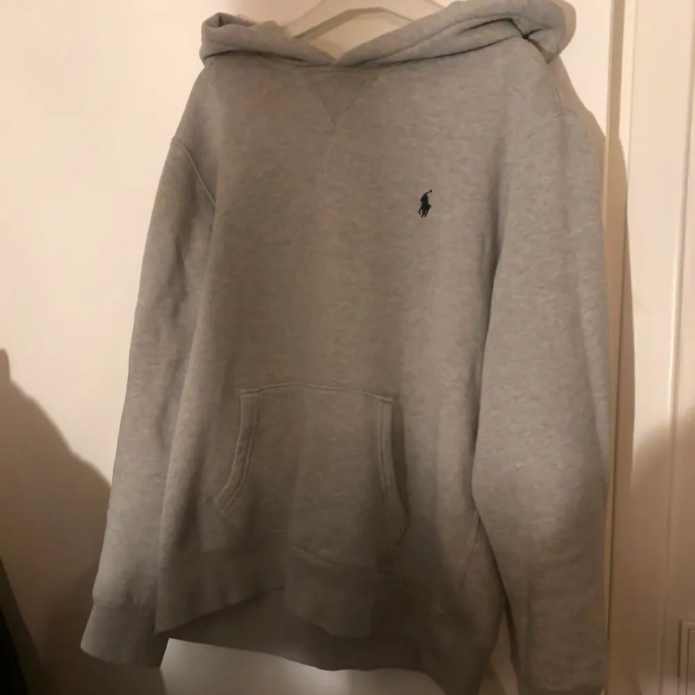 Säljer en klassisk grå hoodie från Polo Ralph Lauren. Den har en liten broderad logga på bröstet och en stor ficka framtill. Perfekt för en avslappnad stil och passar till alla årstider. Superbekväm och stilren! 🐎. Tröjor & Koftor.