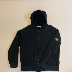 Stone island zip hoodie - En rikgit fet svart Stone island zip up hoodie i väldigt bra och fint skick perfekt nu till vintern, det är storlek XL men sitter mer som m skulle jag säga,               skriv vid minsta fråga eller fundering🔥🔥