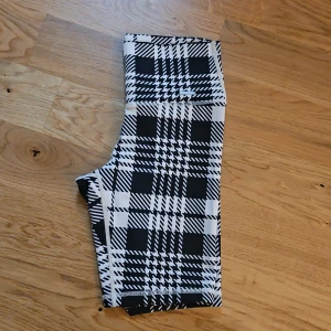 Svartbeige rutiga "cykelbyxor" från Aim'n - Säljer ett par snygga svartbeige rutiga shorts från Aim'n. De är perfekta för träning med sin stretchiga och bekväma passform. Shortsen har ett högmidjat snitt som ger extra stöd och stil. Perfekta för både gymmet och vardagsäventyr! Bild nr tre ger färgen mest rättvisa. Som nya