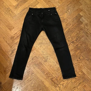 Svarta jeans från Replay - Snygga svarta jeans från Replay med klassisk femficksdesign. De har en rak passform och är perfekta för en stilren look. Tillverkade i ett slitstarkt material som ger en bekväm känsla hela dagen.