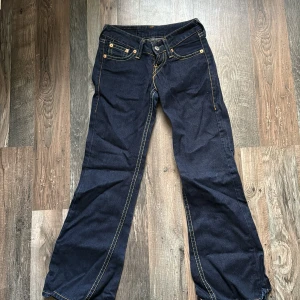 Mörkblå jeans från Levi's - Säljer ett par snygga mörkblå Levi's jeans i mycket bra skick. De har en klassisk femficksdesign med kontrasterande sömmar och en bekväm passform. 
