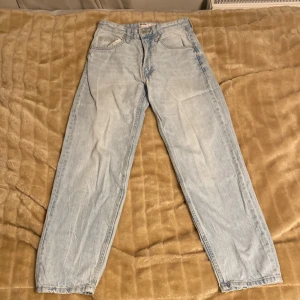 Ljusblå jeans från Bershka - Säljer två par likadana ljusblå jeans från Bershka i storlek 34. De har en '90s wide' stil med en dragkedja och knapp framtill. Perfekta för en avslappnad look och passar bra till både vardag och fest. Använda men i bra skick!