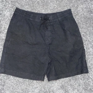 Svarta linne shorts med snörning - Säljer ett par svarta shorts i bra skick. De har en bekväm passform med snörning i midjan för justerbarhet. Perfekta för sommarens alla äventyr eller bara att chilla i. Materialet känns lätt och luftigt. (Accepterar endast Swish pga lurendrejerier) (Checka även andra kläder på min profil och köp tillsammans för ett rabatterat pris)