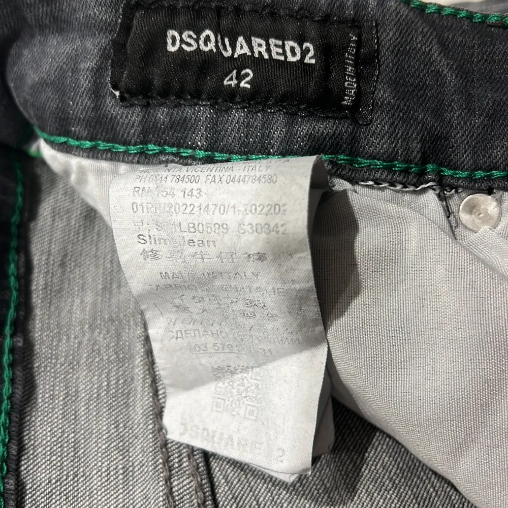 Säljer ett par grå Dsquared2 jeans i slim fit. De har en cool distressed look med slitningar och färgstänk. Perfekta för en avslappnad men stilren outfit. Midjan är normal och de har klassiska fem fickor. Passar perfekt för höst och vår!. Jeans & Byxor.