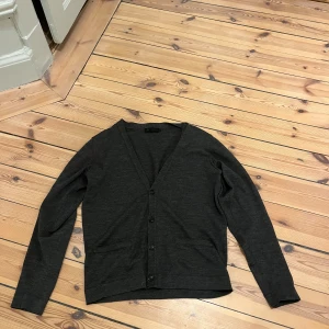 Mörkgrå kofta från Riley - Snygg mörkgrå kofta från Riley med knappar framtill. Perfekt för lager-på-lager och passar till både t-shirt och skjorta. Den har en v-ringad design