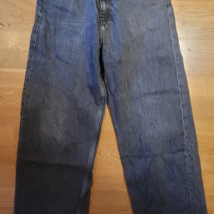 Grå jeans från Galaxy - Snygga grå jeans från Galaxy med en klassisk straight loose fit. Perfekta för en avslappnad stil. De har en traditionell femficksdesign och är tillverkade i slitstarkt denim.