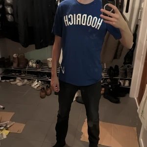 Blå t-shirt från Hoodrich - Säljer en blå t-shirt från Hoodrich med texten 'HOODRICH' på framsidan och 'FROM NOTHING TO SOMETHING' på baksidan. T-shirten har en normal passform och är kortärmad. Perfekt för en avslappnad stil. Tyvär är det skrivet med mitt namn på insidan men inget som syns.