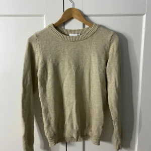 Beige tröja från VILA - Säljer en stilren beige tröja från VILA. Den har en rund halsringning och långa ärmar med ribbade muddar vid ärmslut och nederkant. Perfekt för en avslappnad look.
