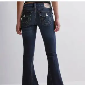 Snygga mörkblå bootcut jeans med dekorativa sömmar och knappar på bakfickorna. Perfekta för en avslappnad stil med en touch av retro. Lågmidjade och tillverkade i jeansmaterial.