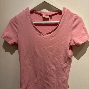 Rosa v-ringad pyjamas t-shirt från Jackpot - Säljer en söt rosa t-shirt från Jackpot med v-ringning. Perfekt som pyjamas. Kortärmad och i mjukt material.