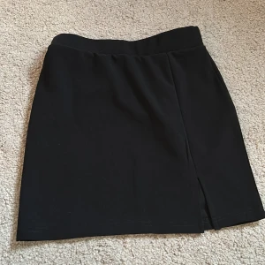 Svart kortkjol med slits - Snygg kjol i storlek xs, aldrig använd ❤️