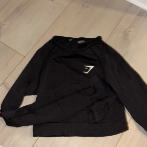 Svart långärmad tröja från Gymshark - Snygg svart långärmad tröja från Gymshark med en logga på bröstet. Perfekt för träning eller en avslappnad dag och är i god skick. 