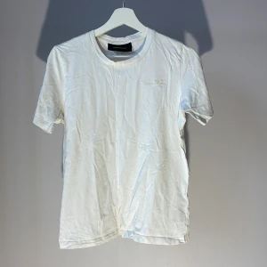 Vit t-shirt från Peak Performance - Snygg vit t-shirt från Peak Performance med broderad logga på bröstet. Perfekt för en avslappnad stil.