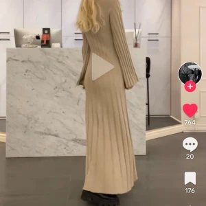 Beige långklänning från Wera - Elegant beige långklänning från Wera i ribbat material. Klänningen har en figurnära passform med långa ärmar och rund halsringning. Perfekt för en stilren look. 