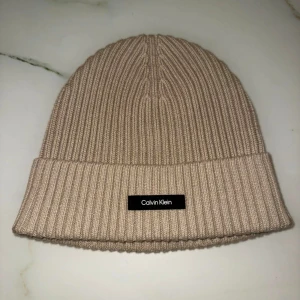 Calvin Clein mössa - Calvin Clein mössa i beige/ljusbrun färg. Oanvänd, endast testat den en gång. Nypris:499:- 