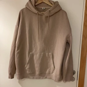 Beige hoodie från Nelly Trend - Säljer en stilren beige hoodie från Weekday. Den har en klassisk känguruficka och justerbar huva med dragsko. Perfekt för en avslappnad look.