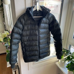 Peak preference  - Snygg svart dunjacka med huva och dragkedja. Perfekt för kyliga dagar med sin quiltade design som håller värmen. Jackan har långa ärmar och en stilren look. Jag har köpt denna jacka på nätet för 2500kr och den är i nyskick köpte mig en annan jacka det är därför jag säljer. Billigare pris desto snabbare affär.         Obs. Tar byten mot allt som finns på min sida, kan lägga till pengar ochså 