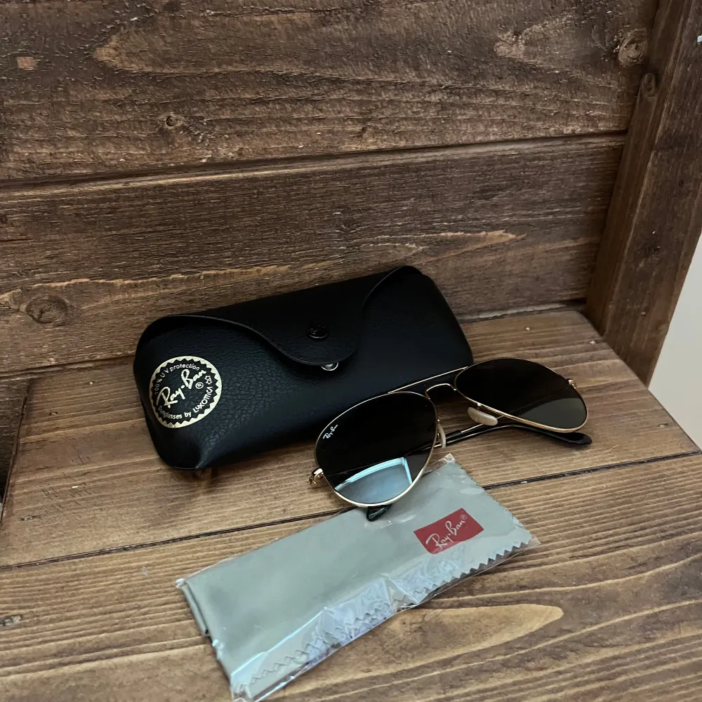 Ett par rayban Aviator i guld med grå svart glas. Storlek large Oöppnad putsduk Fodral i nyskick Använda två gånger . Asusteet.