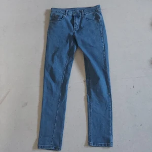 Blå jeans i storlek 28/32 - Säljer ett par klassiska blå jeans i storlek 28/32. De är tillverkade av 98% bomull och 2% spandex, vilket ger dem en skön stretch. Perfekta för vardagsbruk med en snygg och tidlös design. Notera att den har lite defekter.