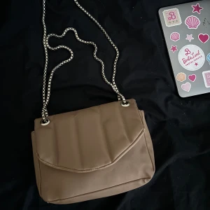 Brun/beige väska - En brun/beige väska med justerbart band. Köpt på bershka i kroatien för några år sedan men knappt använt den därför säljer jag den nu. 