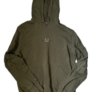 Olivgrön hoodie från Fred Perry - Säljer en snygg olivgrön hoodie från Fred Perry. Den har en klassisk design och sitter perfekt i passformen. Bara att fråga vid funderingar.