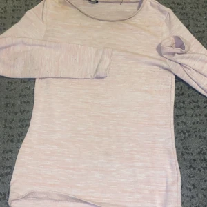 Ljusrosa långärmad tröja - Säljer en superfin ljusrosa långärmad tröja. Perfekt för både vardag och mysiga hemmakvällar. Tröjan är i ett mjukt och bekvämt material som känns skönt mot huden. Passar perfekt till jeans eller leggings!