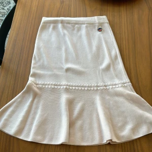 Ljusrosa Busnelkjol med volangdetalj - Säljer en superfin ljusrosa Busnel kjol med volangdetalj längst ner. Kjolen har en enkel design med en broderad logga. Perfekt för både vardag och fest! 🥰