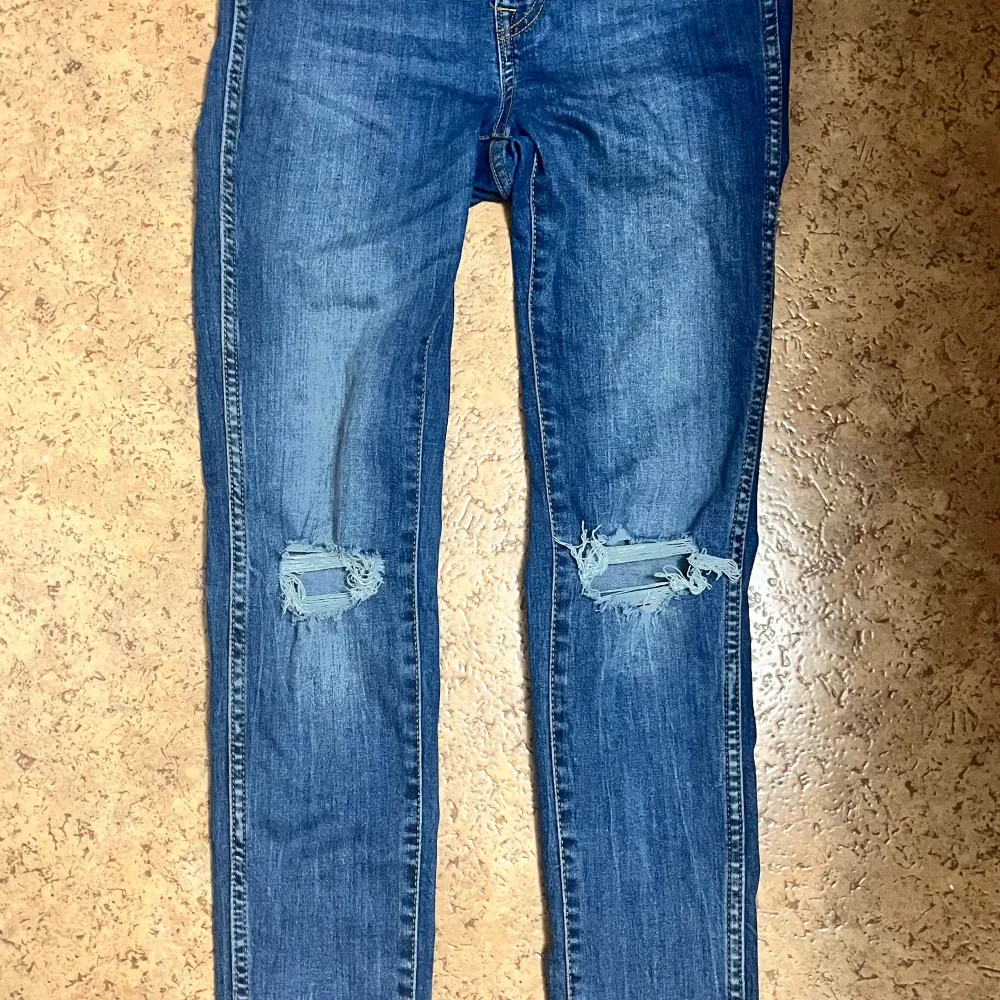 Högmidjade skinny jeans med slitningar vid knäna från Lager 157 i storlek XS. De är i mycket fint skick. Säljs pågrund av att de inte passar mig längre.  . Jeans & Byxor.