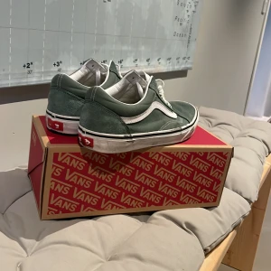 Ett par Vans old skool i färgen duck green storlek 42,5 - Duck green old skool vans i storlek 42,5 med box. Väldigt bra skick/använda någon gång
