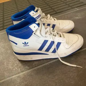 Vita adidas sneakers med blå detaljer  Liten skada på skon, kolla sista bilden