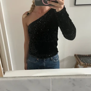Fest topp från bikbok. En arm  - Super bra skick. Den perfekta fest toppen. Svart med paljetter