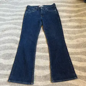 Säljer ett par snygga blå bootcut jeans i bra skick. De har en klassisk femficksdesign och är perfekta för både vardag och fest. Jeansen är tillverkade i ett slitstarkt denimtyg och har en bekväm passform. Perfekta för höst och vår!