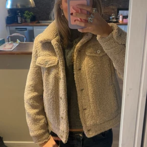 Beige teddyjacka - Mysig beige teddyjacka i mycket bra skick. Perfekt för höst och vinter med sin varma och fluffiga stil. Jackan har långa ärmar och knappar framtill samt två bröstfickor med knappar. Den är både trendig och bekväm💕💕😊