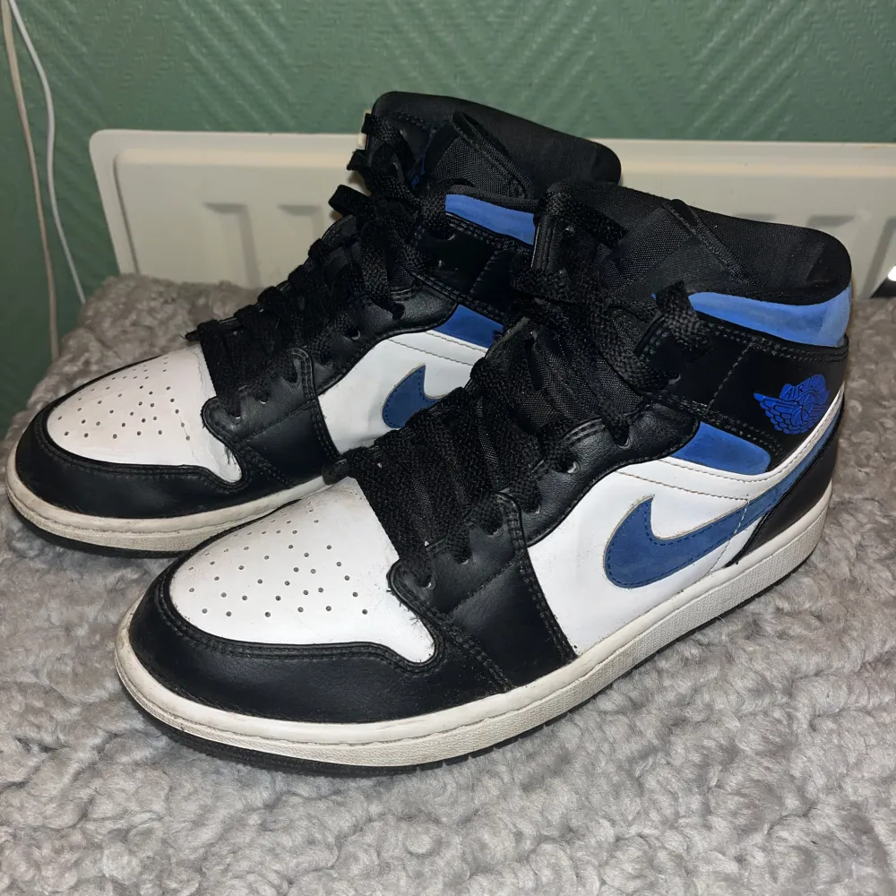 Säljer ett par Nike Air Jordans i mycket bra skick. Skorna har en snygg kombination av svart, blå och vit färg med klassisk snörning. Perfekta för både vardag och fest. Knappt använda. Skor.