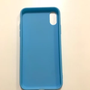 Blått mobilskal för iPhone X/XS - Säljer ett snyggt och stilrent blått mobilskal för iPhone X/XS. Inte använd. Skalet är gjort av mjukt material som ger ett bra grepp och skyddar din telefon mot repor och stötar. Perfekt för dig som vill ha ett enkelt men effektivt skydd för din mobil. Passar perfekt i fickan och är lätt att ta av och på.