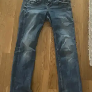 Säljer ett par snygga blå jeans från Pepe Jeans i bra skick. De har en regular waist (låg midjade enligt mig) och straight leg passform, perfekt för en avslappnad stil. Jeansen har en klassisk design med fem fickor och en bekväm passform. Perfekta för både vardag och fest!