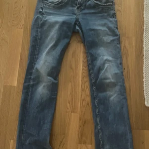 Blå jeans från Pepe Jeans - Säljer ett par snygga blå jeans från Pepe Jeans i bra skick. De har en regular waist (låg midjade enligt mig) och straight leg passform, perfekt för en avslappnad stil. Jeansen har en klassisk design med fem fickor och en bekväm passform. Perfekta för både vardag och fest!